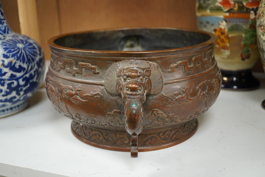 A large Chinese archaistic bronze censer, decorated in relief, with twin handles, 38cm in diameter